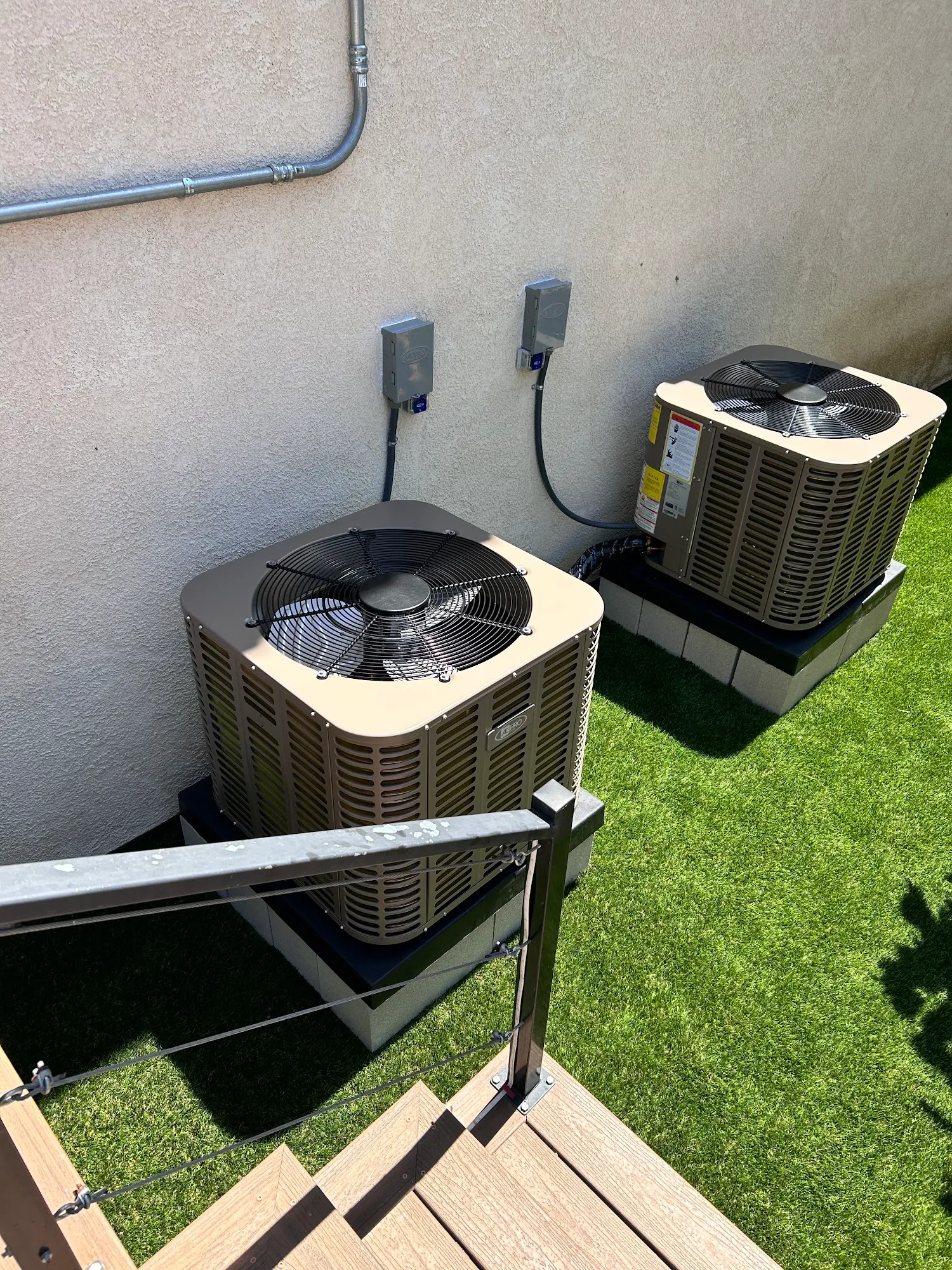 Two new air conditioning condensers installed on a North County patio